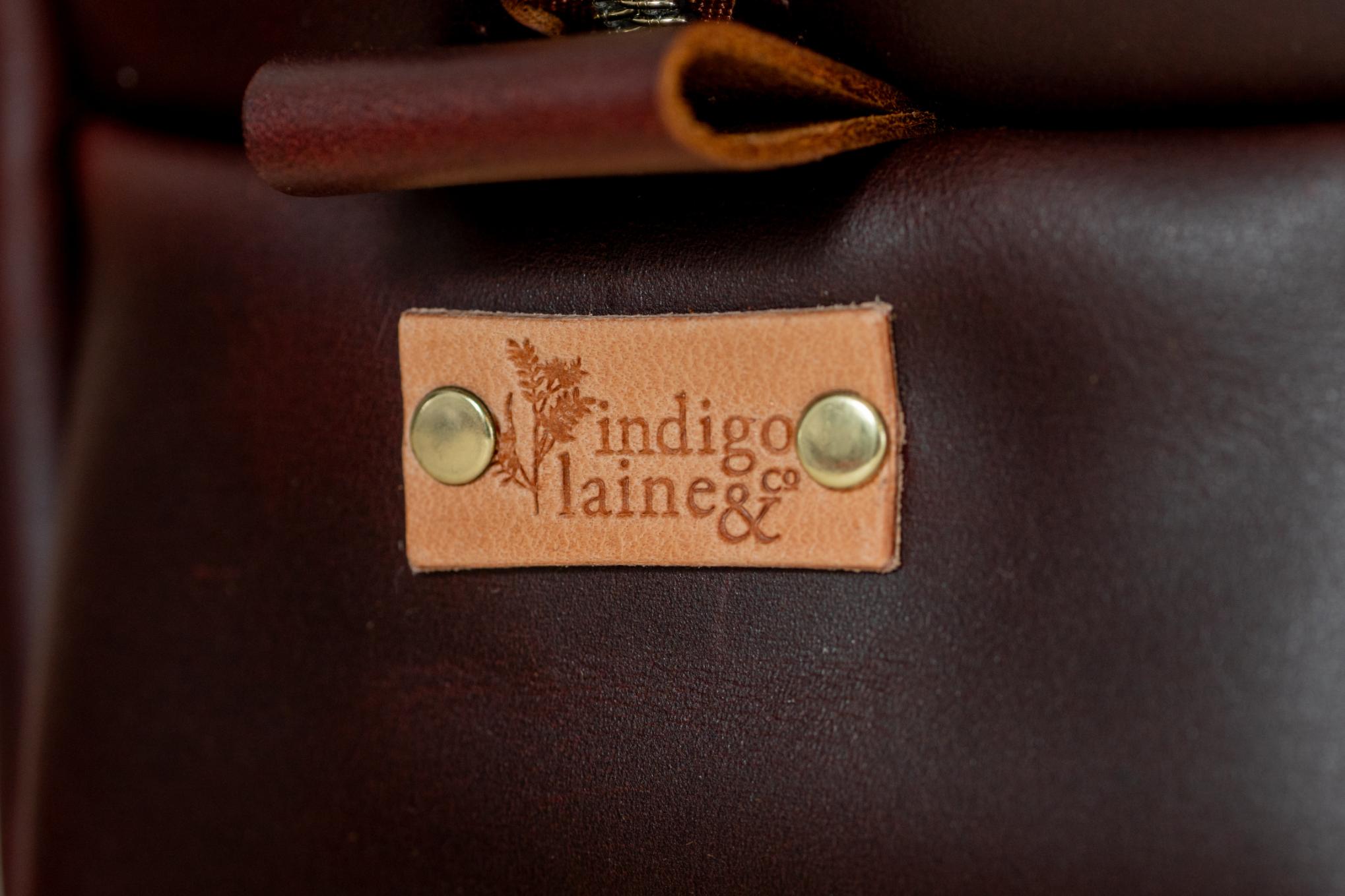 Close-up of Indigo Laine The Toiletry Kit in Tobacco, showing the Indigo Laine logo