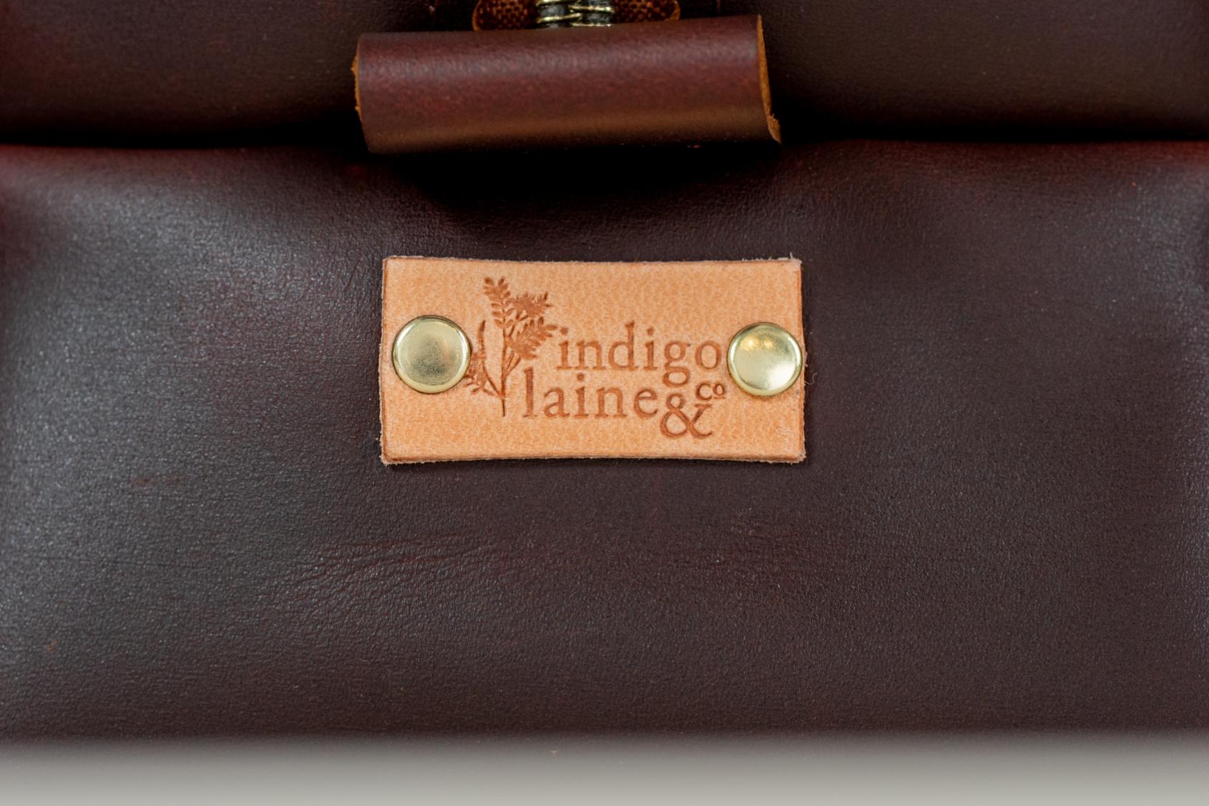 Close-up of Indigo Laine The Toiletry Kit in Tobacco, showing the Indigo Laine logo
