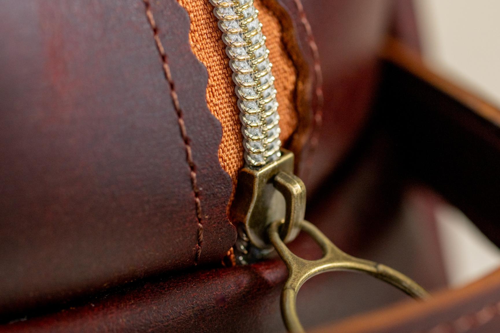 Close-up of Indigo Laine The Toiletry Kit in Tobacco, showing the scallop design and zipper
