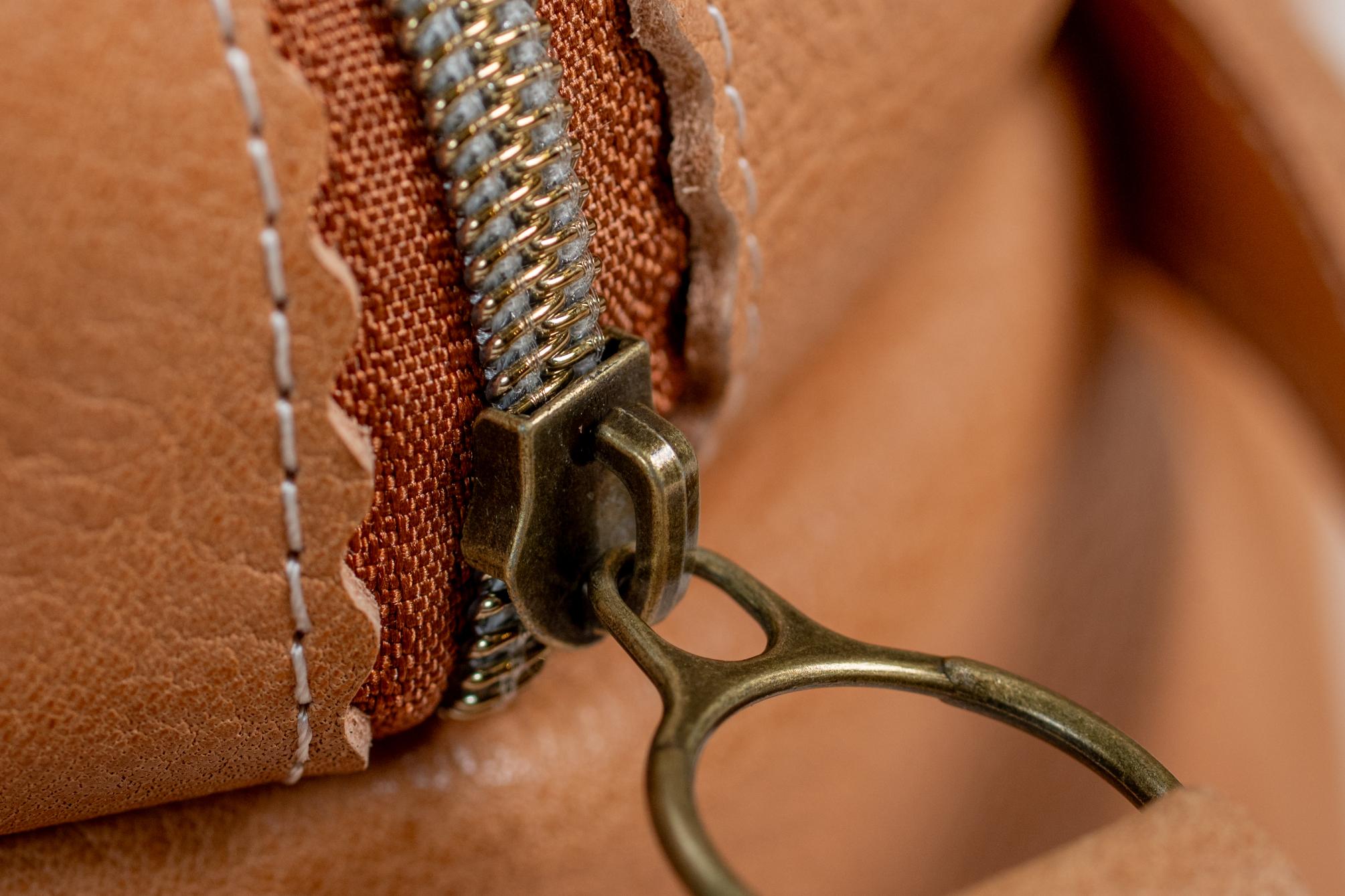 Close-up of Indigo Laine The Toiletry Kit in Camel, showing the zipper
