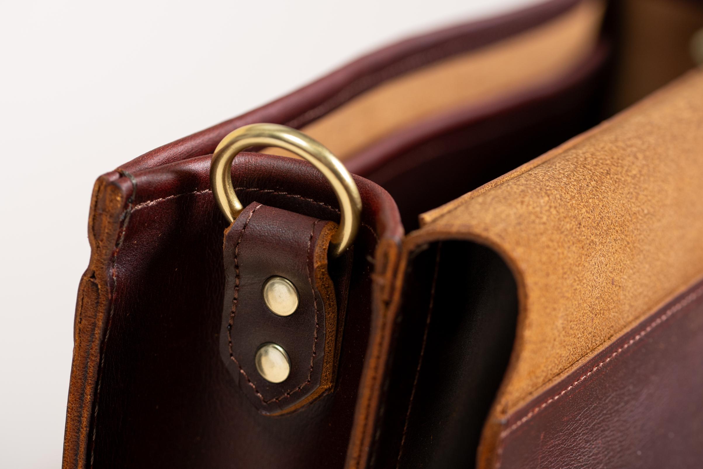 Close-up of Indigo Laine The Satchel in Tobacco, showing solid brass hardware