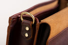 Close-up of Indigo Laine The Satchel in Tobacco, showing solid brass hardware