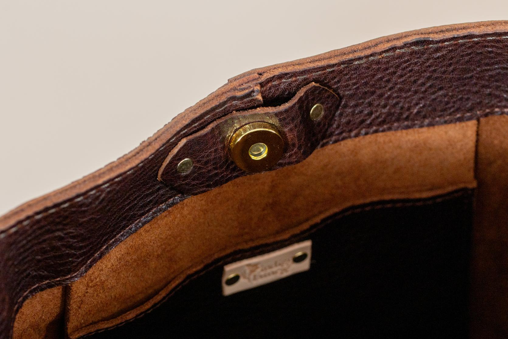 Leather bag brass turn-lock closure detail