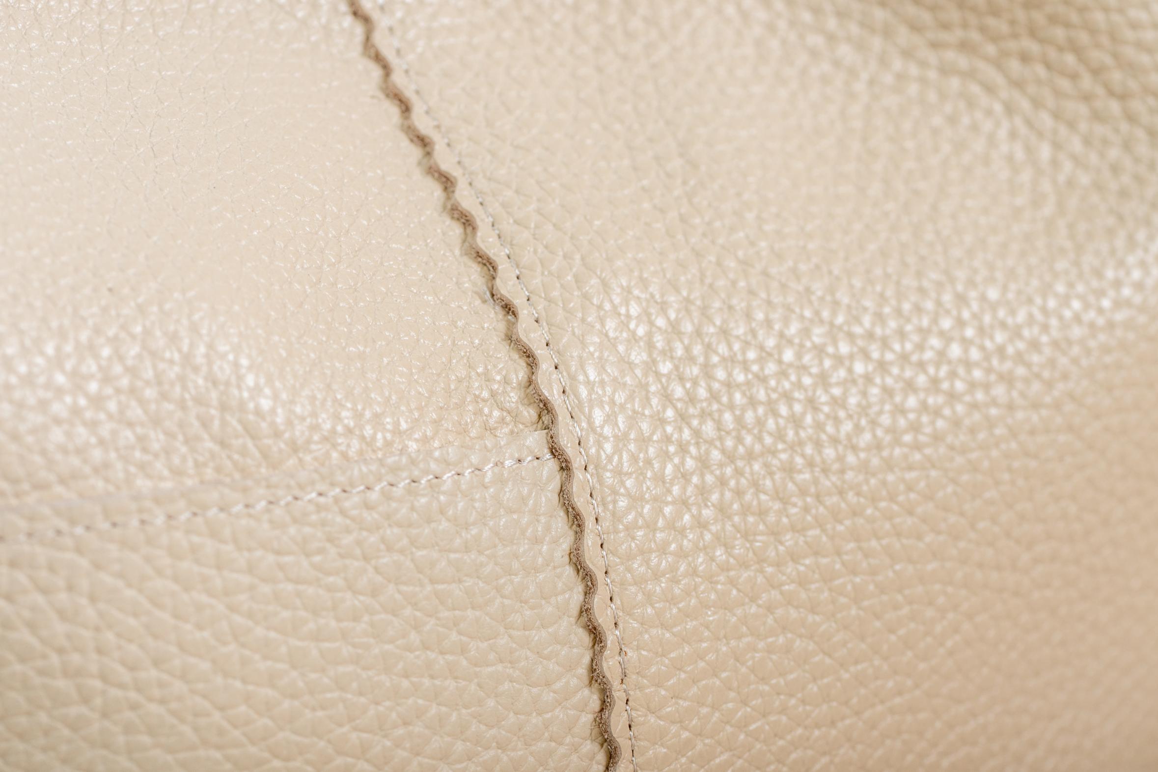 Cream leather grain and stitching macro detail