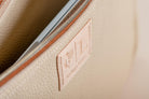 Close-up of Indigo Laine The Laptop Sleeve in Bone, showing the Indigo Laine logo and zipper