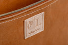 Close-up of Indigo Laine The Laptop Sleeve in Camel, showing the Indigo Laine log and zipper