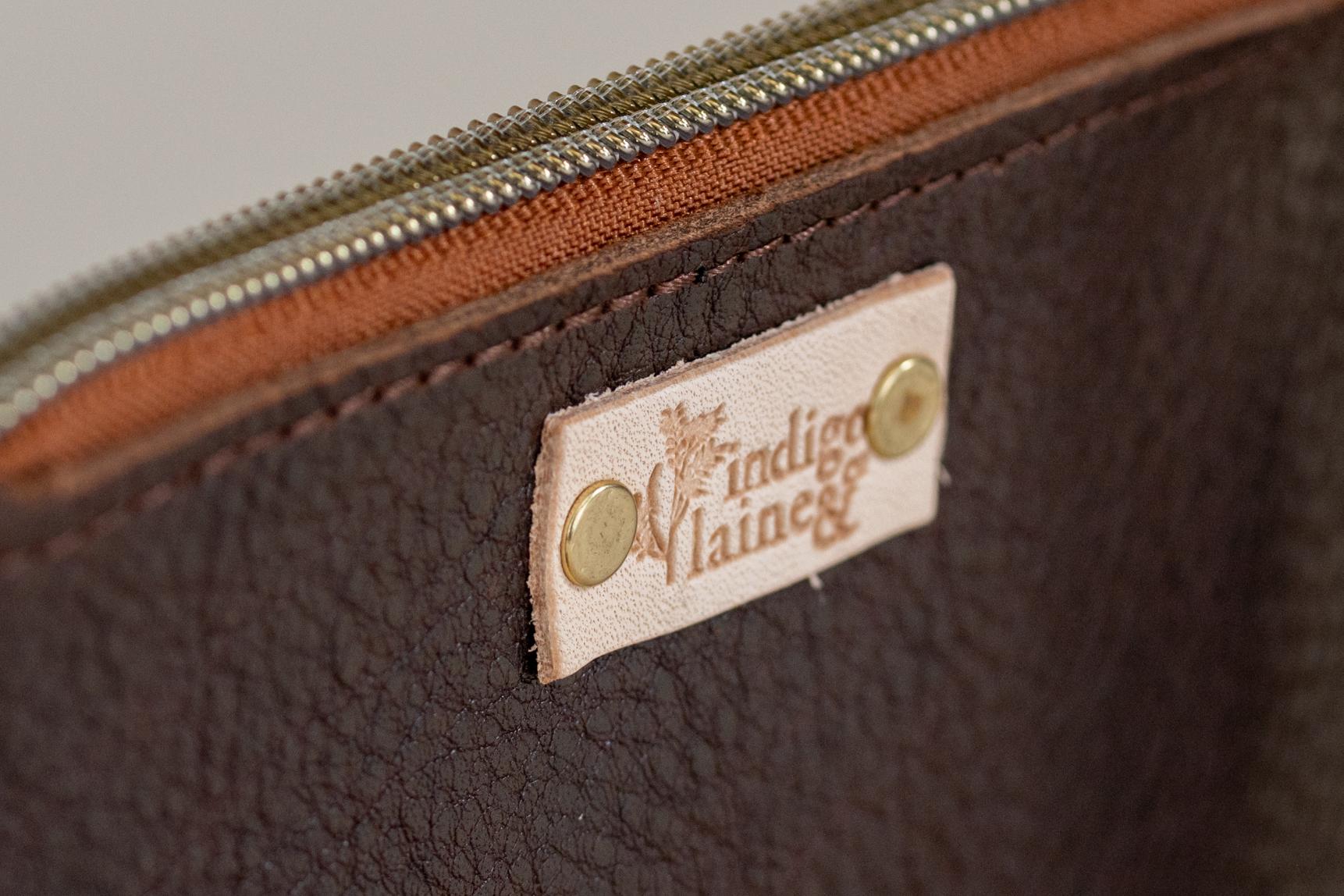 Close-up of The Cami wallet's tobacco leather and brand tag