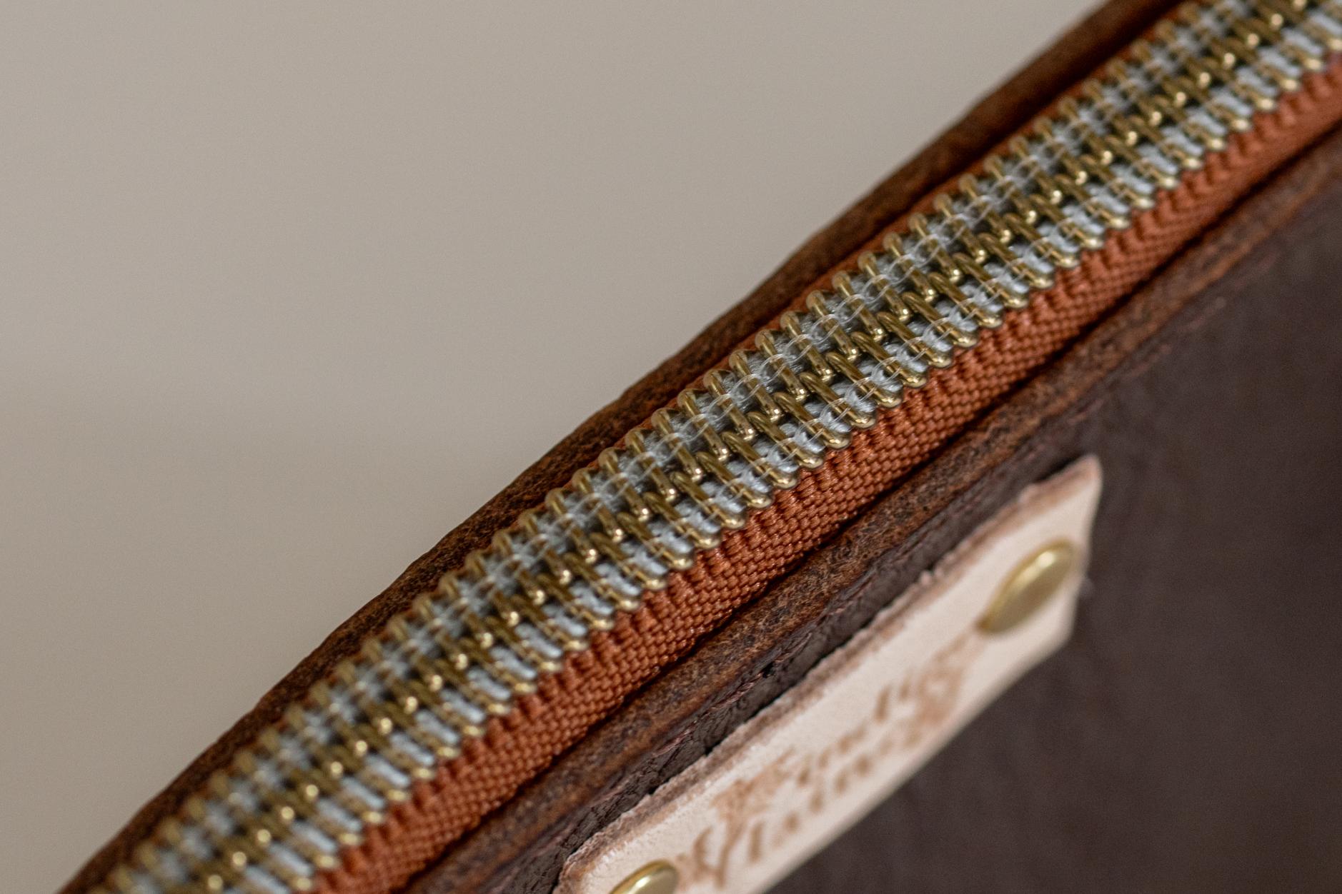 Close-up of The Cami wallet's zipper and tobacco leather edge
