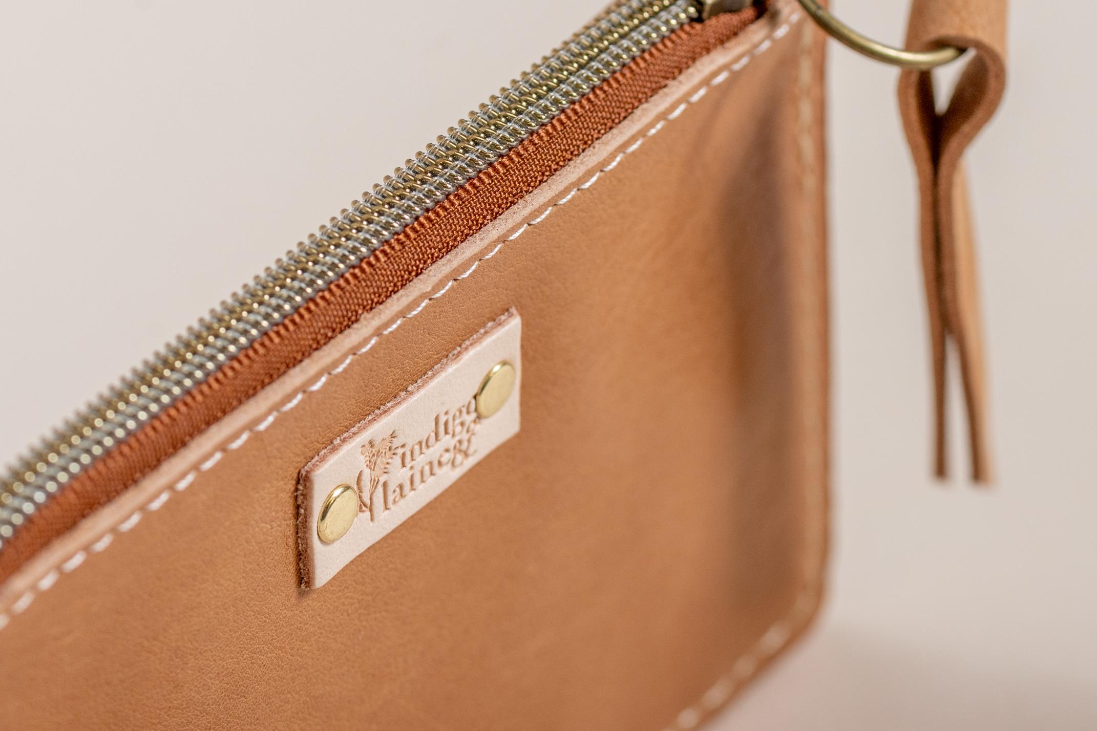 Close-up of The Cami wallet's camel leather and brand tag