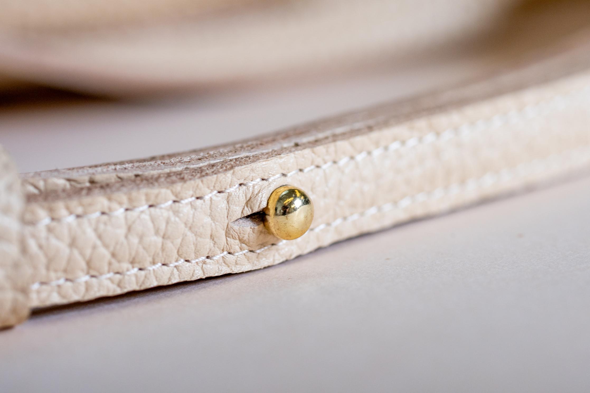 Close-up of The Shelly Crossbody's cream strap and gold stud detail