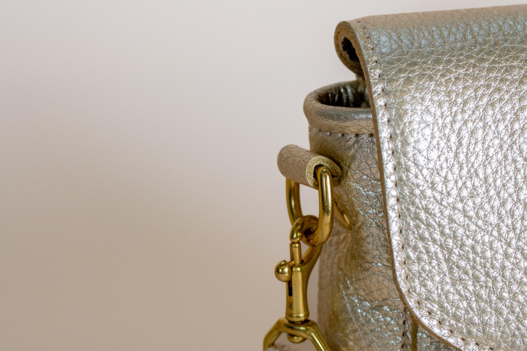 Close-up of The Shelly Crossbody's gold clasp and strap attachment.