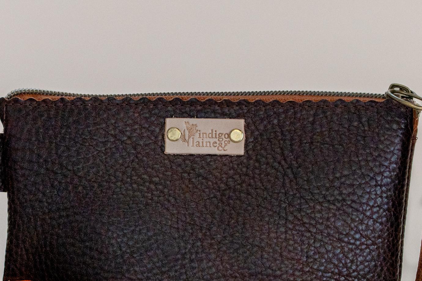 Close-up of The Sloane's zip closure and brand tag in dark brown