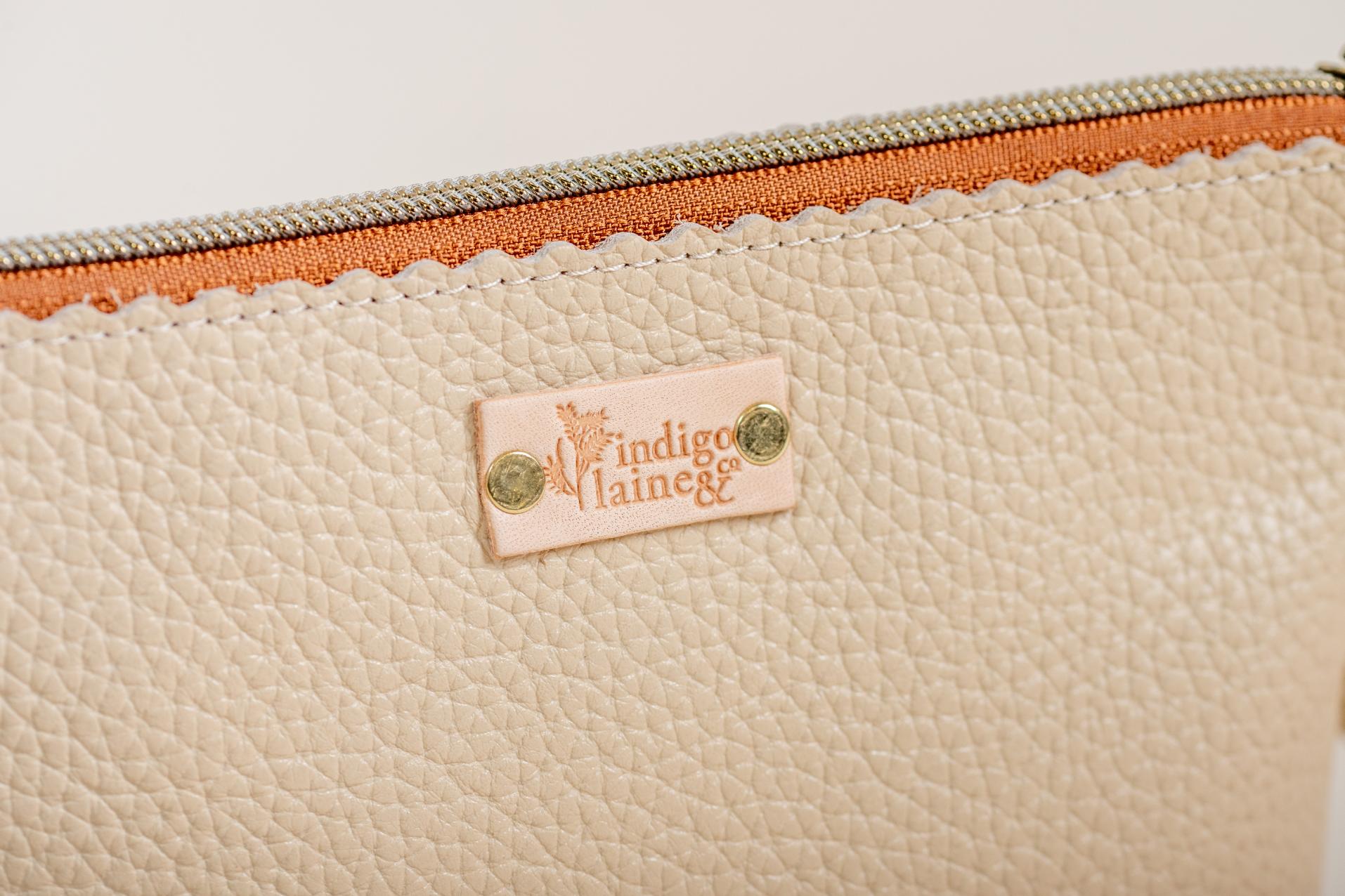 Close-up of The Sloane's cream leather and brand tag