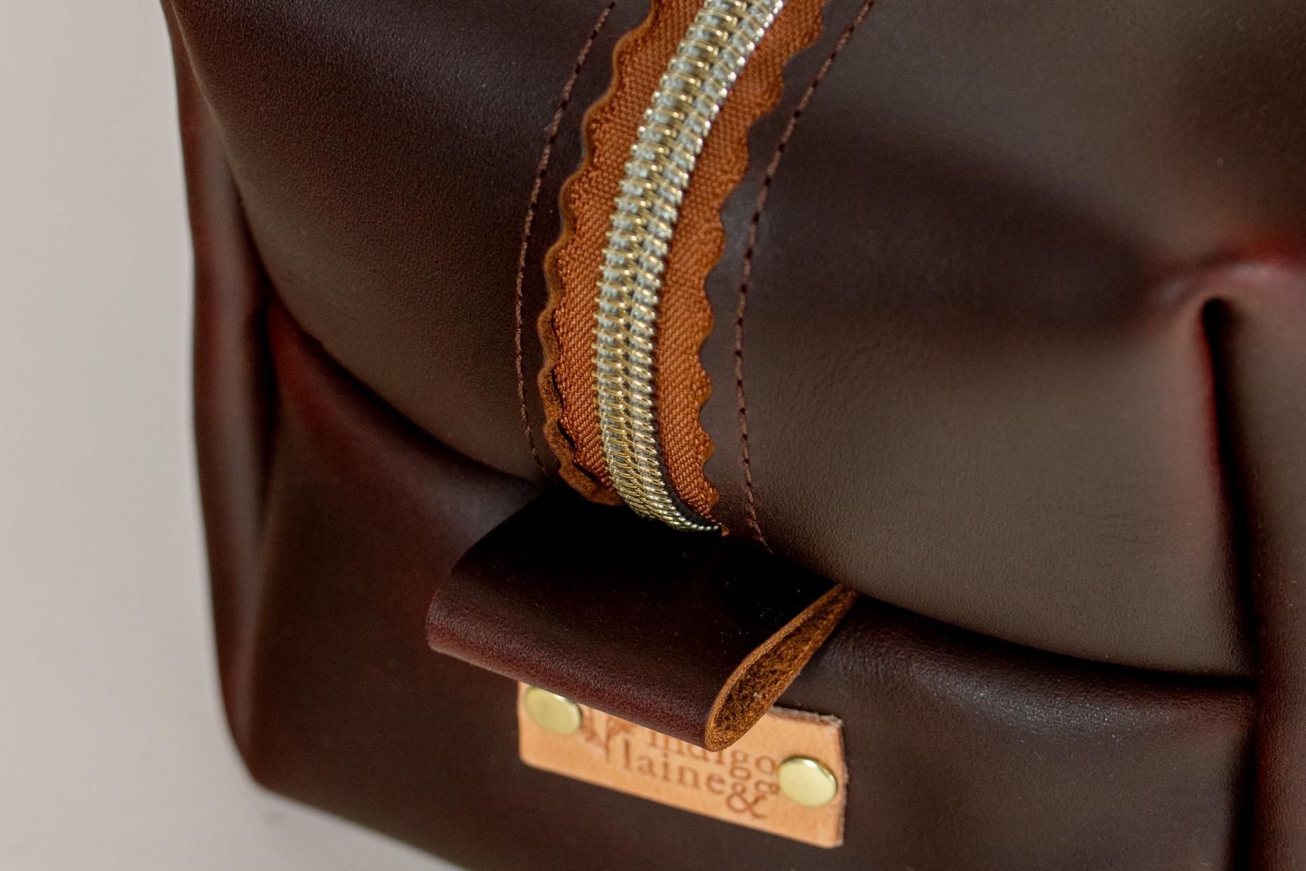 Close-up of Indigo Laine The Toiletry Kit in Tobacco, showing the scallop design and zipper