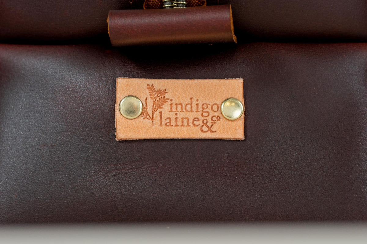 Close-up of Indigo Laine The Toiletry Kit in Tobacco, showing the Indigo Laine logo