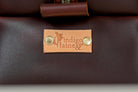 Close-up of Indigo Laine The Toiletry Kit in Tobacco, showing the Indigo Laine logo