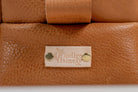 Close-up of Indigo Laine The Toiletry Kit in Camel, showing the Indigo Laine logo