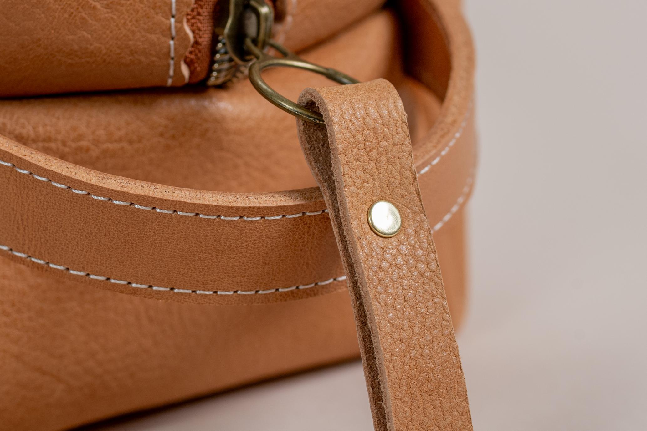Close-up of Indigo Laine The Toiletry Kit in Camel, showing the strong leather handle