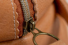 Close-up of Indigo Laine The Toiletry Kit in Camel, showing the zipper