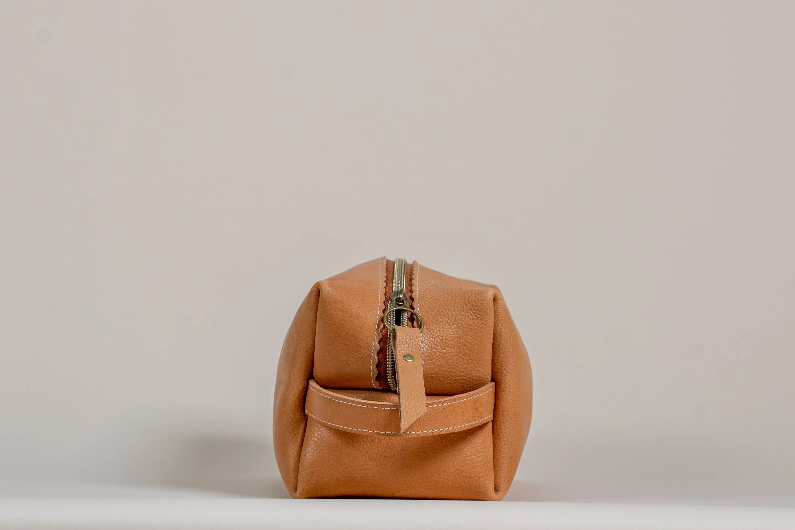 Indigo Laine The Toiletry Kit in Camel, showing the scallop design and zipper