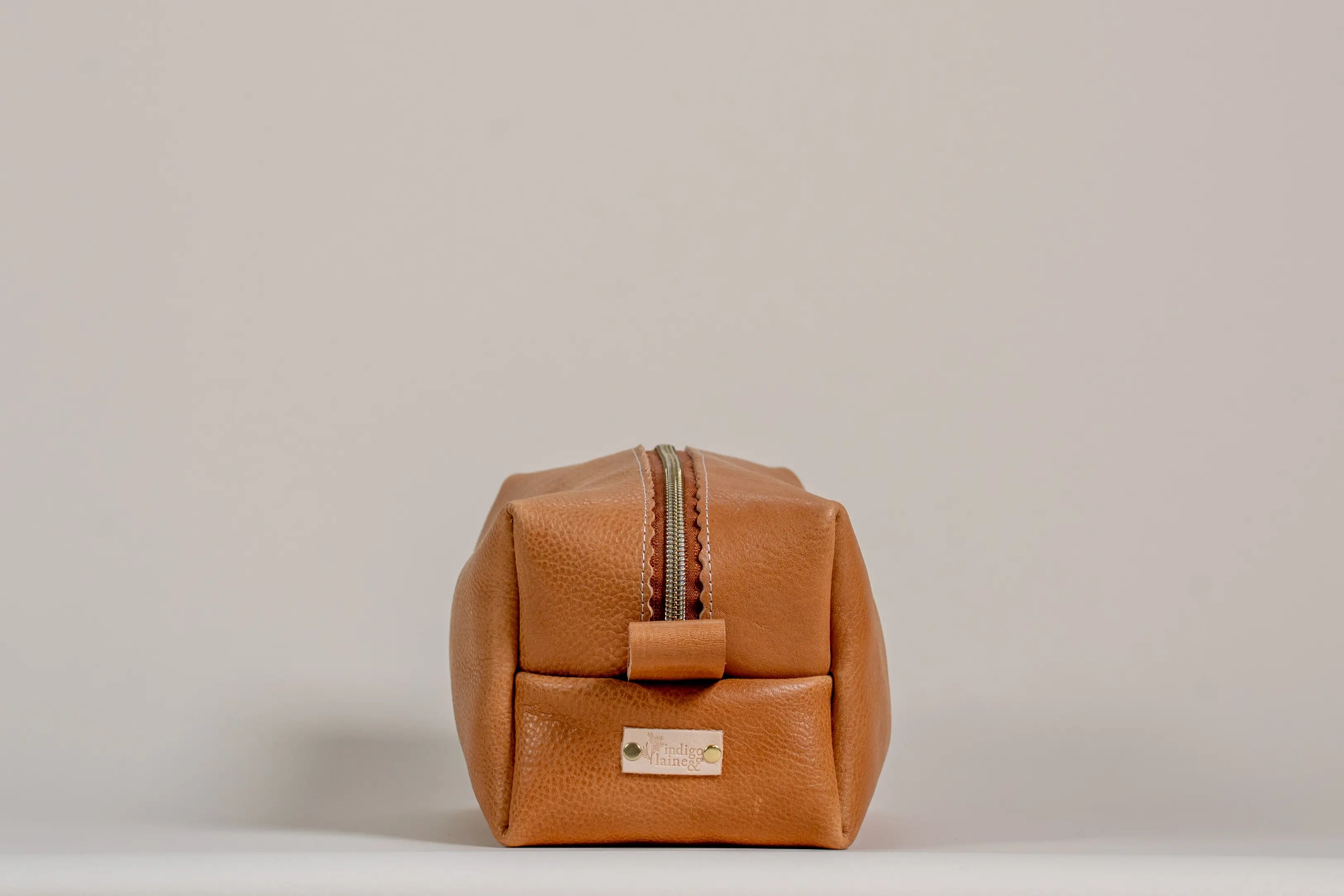 Indigo Laine The Toiletry Kit in Camel, showing the scallop design and zipper
